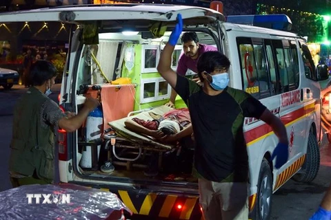 Nhân viên y tế chuyển người bị thương trong vụ đánh bom liều chết bên ngoài sân bay Kabul, Afghanistan. (Ảnh: AFP/TTXVN)