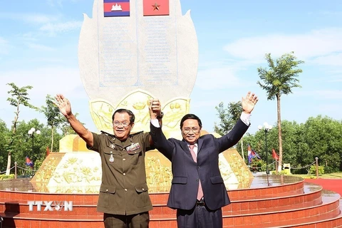 Thủ tướng Phạm Minh Chính và Thủ tướng Campuchia Samdech Techo Hun Sen chụp ảnh chung tại Khu vực X16, điểm dừng chân trong hành trình cứu nước của Thủ tướng Hun Sen tại xã Lộc Tấn, huyện Lộc Ninh, tỉnh Bình Phước, sáng 20/6/2022. (Ảnh: Dương Giang/TTXVN)