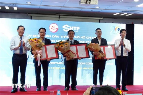 Trao chứng nhận điều chỉnh đầu tư vào Khu Công nghệ cao Thành phố Hồ Chí Minh cho ba dự án với vốn đầu tư tăng thêm hơn 841 triệu USD và 180 tỷ đồng. (Ảnh: Tiến Lực/TTXVN)
