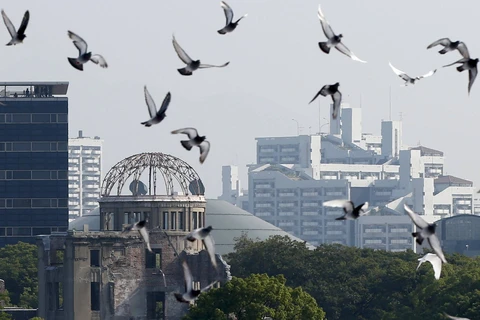 Chim bồ câu bay qua Công viên Tưởng niệm Hòa bình gần Vòm bom nguyên tử ở Hiroshima. (Nguồn: Reuters)