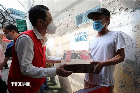 Chủ tịch Hội Chữ thập Đỏ thành phố Hà Nội Đào Ngọc Triệu tặng quà cho người dân xóm chạy thận. (Ảnh: Thanh Tùng/TTXVN)