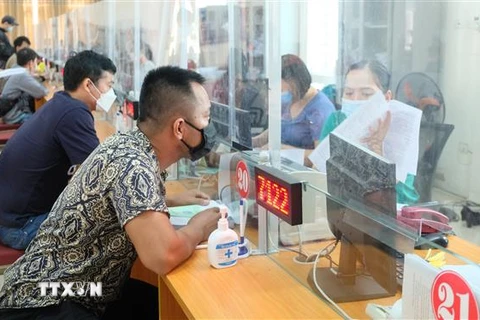 Người lao động làm thủ tục nhận bảo hiểm thất nghiệp Trung tâm Dịch vụ việc làm tỉnh Thanh Hóa. (Ảnh: Khiếu Tư/TTXVN)