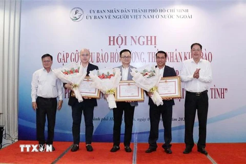 Ông Nguyễn Thành Trung (ngoài cùng bên phải), Phó Chủ tịch Ủy ban MTTQ Việt Nam Thành phố và ông Võ Thành Chất (ngoài cùng bên trái), Phó Chủ nhiệm Ủy ban về Người Việt Nam ở nước ngoài Thành phố, trao Bằng khen của UBND Thành phố cho 3 kiều bào có những 