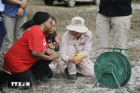 Thứ trưởng Bonnie Denise Jenkins ấn nút hủy nổ tại hiện trường xử lý bom mìn khu vực xã Triệu Sơn, huyện Triệu Phong. (Ảnh: Thanh Thủy/TTXVN)