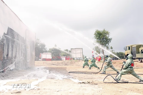 Lực lượng phòng hóa của Việt Nam phun thuốc khử độc tại một vụ rò rỉ khí độc trong một tình huống giả định tại buổi diễn tập. (Ảnh: Phạm Kiên/TTXVN)