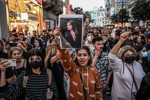 Một người biểu tình cầm bức chân dung của Mahsa Amini, một phụ nữ trẻ Iran đã chết sau khi bị cảnh sát bắt giữ ở Tehran. (Nguồn: AFP)