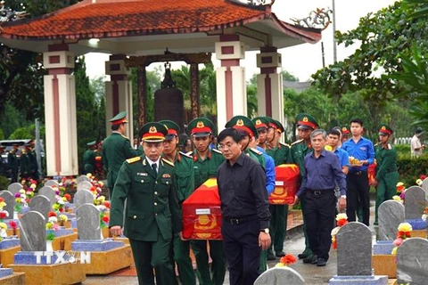 Đưa các hài cốt liệt sỹ về nơi an táng tại nghĩa trang liệt sỹ huyện Cam Lộ. (Ảnh:Nguyên Linh/TTXVN)