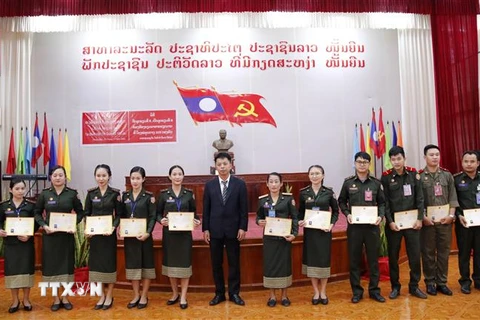 Đại diện Đại sứ quán Việt Nam tại Lào chụp ảnh lưu niệm với các học viên lớp tiếng Việt cơ bản khóa 5 tại buổi lễ. (Ảnh: Phạm Kiên/TTXVN)