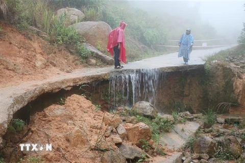 Tuyến đường bêtông từ Trạm y tế xã Sơn Dung (Sơn Tây) đi thôn Gò Lã bị sạt lở nghiêm trọng sau mưa. (Ảnh: Phạm Cường/TTXVN)