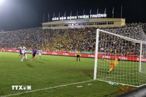 Tình huống đáng chú ý trong trận đấu giữa CLB Nam Định (áo trắng) và CLB Sài Gòn (áo đỏ). (Ảnh: Công Luật/TTXVN)