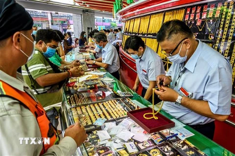 Người dân mua bán vàng tại một cửa hàng ở Bangkok, Thái Lan. (Ảnh: AFP/TTXVN)