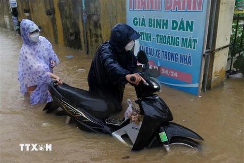 Thành phố Quy Nhơn ngập nặng do mưa lớn. Nhiều nơi nước ngập hơn nửa thân xe máy. (Ảnh: Lê Ngọc Phước/TTXVN)