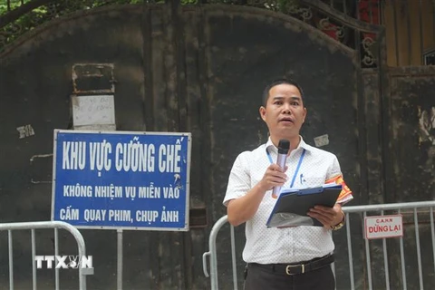 Đại diện chính quyền đọc quyết định cưỡng chế đối với trường hợp vi phạm. (Ảnh: Nguyễn Thắng/TTXVN)
