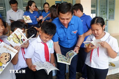 Bí thư Tỉnh đoàn Long An Trần Hải Phú với học sinh Trường tiểu học Nhơn Hòa tại buổi trao tặng Tủ sách Đinh Hữu Dư. (Ảnh: Đức Hạnh/TTXVN)