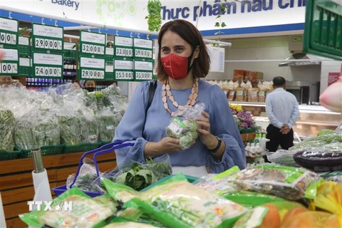 Đại sứ New Zealand tại Việt Nam Tredene Dobson mua rau an toàn tại siêu thị Co.op Mark Quy Nhơn do nông dân Bình Định sản xuất từ dự án Rau an toàn Bình Định. (Ảnh: Kha Phạm/TTXVN)