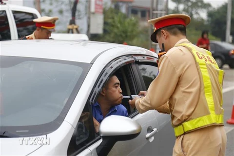Cảnh sát giao thông huyện Sơn Dương kiểm tra nồng độ cồn của lái xe. (Ảnh: Nam Sương/TTXVN)