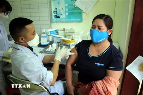 Nhân viên Trạm y tế phường Lam Sơn, thành phố Thanh Hóa tiêm vắc xin phòng dịch COVD-19 cho người dân. (Ảnh: Nguyễn Nam/TTXVN)