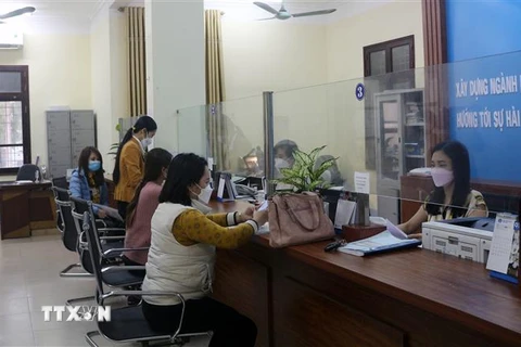 Người lao động làm các thủ tục để hưởng chế độ tại Bảo hiểm xã hội tỉnh Hà Nam. (Ảnh: Nguyễn Chinh/TTXVN)