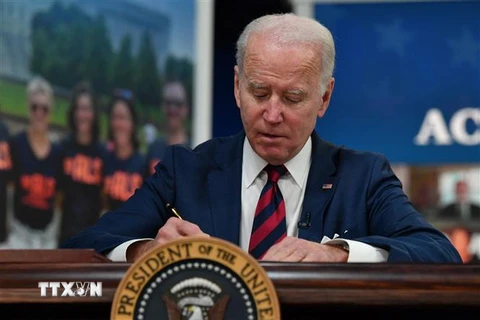 Tổng thống Mỹ Joe Biden ký một đạo luật tại Nhà Trắng ở Washington, DC. (Ảnh: AFP/TTXVN)