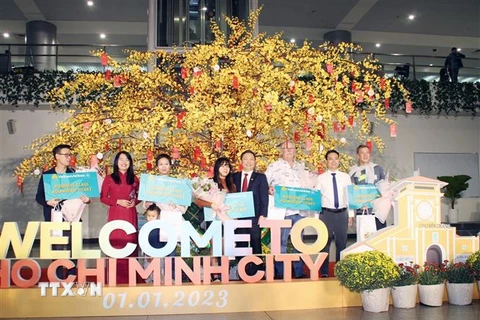 Tặng quà cho 6 vị khách may mắn được chọn trên chuyến bay quốc tế VN30 bay từ Frankfurt, Đức đến Thành phố Hồ Chí Minh hạ cánh lúc 7 giờ 25 phút, ngày 1/1/2023. (Ảnh: Mỹ Phương/TTXVN)