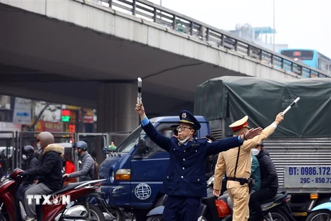 Lực lượng Thanh tra giao thông, cảnh sát giao thông hướng dẫn các phương tiện đi theo đúng tuyến đường. (Ảnh: Huy Hùng/TTXVN)