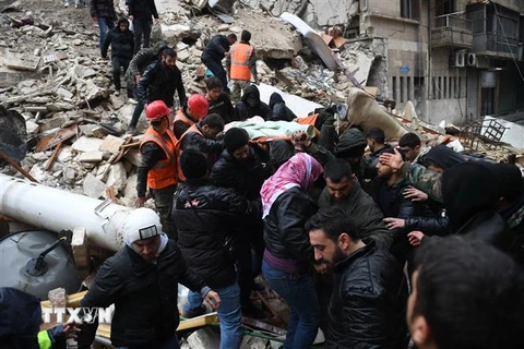 Lực lượng cứu hộ chuyển nạn nhân ra khỏi đống đổ nát sau trận động đất tại tỉnh Aleppo, Syria. (Ảnh: AFP/TTXVN)