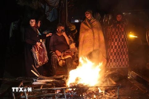 Người dân đốt lửa sưởi ấm sau khi bị mất nhà cửa do động đất tại Kahramanmaras, Thổ Nhĩ Kỳ. (Ảnh: AFP/TTXVN)