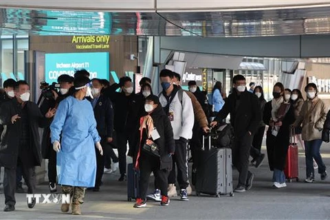 Du khách Trung Quốc được hướng dẫn tới khu vực kiểm dịch COVID-19 tại sân bay quốc tế Incheon, phía Tây Seoul (Hàn Quốc). (Ảnh: YONHAP/TTXVN)