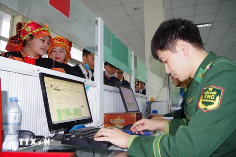 Cán bộ Cửa khẩu Quốc tế Ma Lù Thàng làm thủ tục xuất cảnh cho người dân Việt Nam sang Trung Quốc. (Ảnh: Nguyễn Oanh/TTXVN)