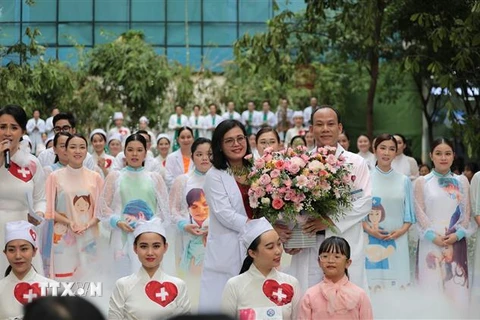 Phó Giáo sư, Tiến sỹ, Bác sỹ Hoàng Thị Diễm Tuyết, Giám đốc Bệnh viện Hùng Vương nhận hoa cảm ơn từ Ban tổ chức Chương trình "Mầm sống." (Ảnh: Đinh Hằng/TTXVN)