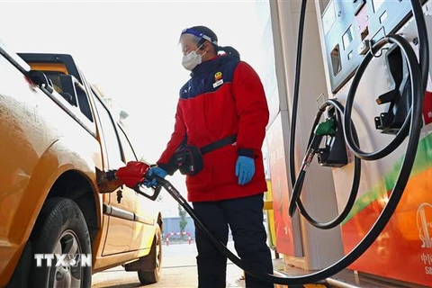 Bơm xăng cho phương tiện tại trạm xăng ở tỉnh Giang Tô, Trung Quốc. (Ảnh: THX/TTXVN)