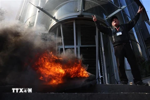 Người biểu tình đốt phá ngân hàng ở Beirut, Liban, ngày 16/2. (Ảnh: AFP/TTXVN)