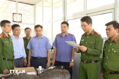 Cơ quan điều tra đọc lệnh khám xét tại nơi làm việc của Nguyễn Văn Chiến. (Ảnh: TTXVN phát)
