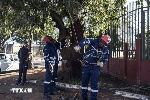 Công nhân sửa chữa đường dây điện tại Johannesburg, Nam Phi. (Ảnh: AFP/TTXVN)