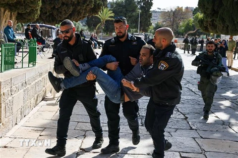 Cảnh sát Israel bắt giữ một người đàn ông Palestine sau các cuộc đụng độ tại khu vực đền Al-Aqsa (mà Israel gọi là Núi Đền) ở Jerusalem ngày 5/4. (Ảnh: AFP/TTXVN)