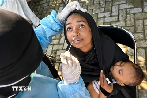 Nhân viên y tế lấy mẫu xét nghiệm COVID-19 cho người dân tại tỉnh Aceh, Indonesia. (Ảnh: AFP/TTXVN)