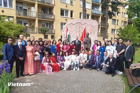Bà con cộng đồng cùng các vị khách mời Hungary chụp ảnh kỷ niệm bên tượng Bác. (Ảnh: Hoàng Linh/Vietnam+)