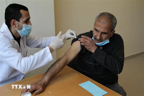Nhân viên y tế tiêm vaccine ngừa COVID-19 cho người dân Palestine tại Dải Gaza. (Ảnh: THX/TTXVN)
