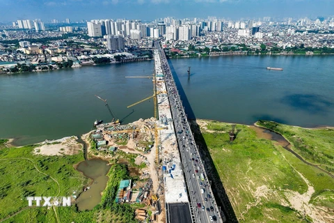 Sáng 30/5, tại Hà Nội, dự án cầu Vĩnh Tuy giai đoạn 2 (Vĩnh Tuy 2) đã chính thức hợp long đoạn cầu chính vượt sông Hồng, chuyển sang giai đoạn “nước rút” để chuẩn bị thông xe vào đầu tháng 9/2023. (Ảnh: Trung Nguyên/TTXVN)