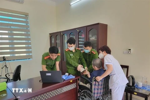 Công an Quảng Ninh thực hiện các bước cấp căn cước công dân cho người tàn tật. (Ảnh: TTXVN phát)