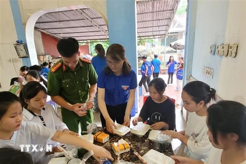 Những phần cơm nóng hổi được trao tận tay các thí sinh lúc rời phòng thi. (Ảnh: Vũ Hoàng Giang/TTXVN)