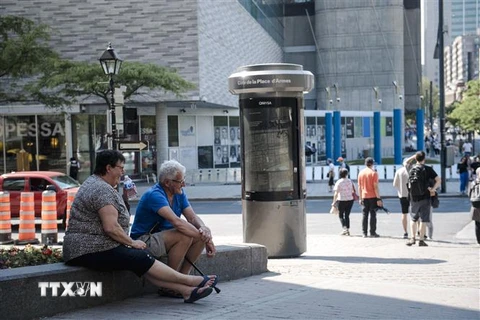 Người dân tránh nắng dưới bóng râm tại Montreal, Quebec, Canada. (Ảnh: AFP/TTXVN)