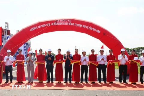 Phó Thủ tướng Chính phủ Trần Hồng Hà (thứ 6 từ trái) và các đại biểu cắt băng tại lễ thông xe. (Ảnh: Thanh Thương/TTXVN)