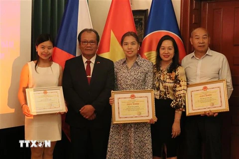 Các cá nhân được tặng giấy khen chụp ảnh lưu niệm cùng đại diện Đại sứ quán Việt Nam tại Cộng hòa Séc. (Ảnh: Ngọc Biên/TTXVN)