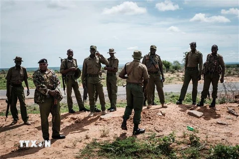 Lực lượng an ninh gác tại lối vào rừng Shakahola, gần thị trấn Malindi, Kenya, nơi hàng chục thi thể các tín đồ của một giáo phái được khai quật. (Ảnh: AFP/TTXVN)