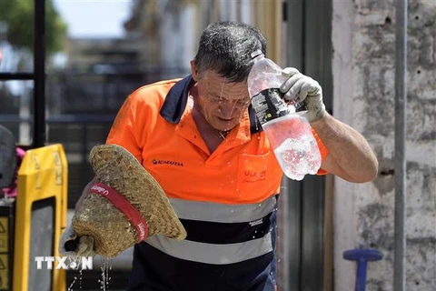 Công nhân làm mát dưới trời nắng nóng ở Sevilla, Tây Ban Nha. (Ảnh: AFP/TTXVN)