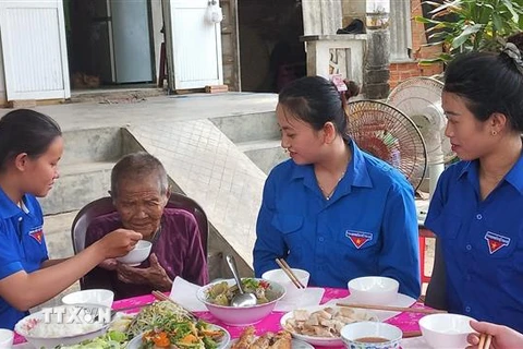 Các bạn đoàn viên thanh niên chăm sóc Mẹ Việt Nam Anh hùng Cao Thị Chánh (99 tuổi) ở thôn Hiền Lương, xã Nghĩa Hà, thành phố Quảng Ngãi. (Ảnh: Đinh Hương/TTXVN)