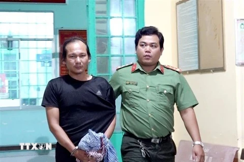 Lực lượng Công an bắt, áp giải Nguyễn Hoàng Nam về nơi giam giữ. (Ảnh: TTXVN phát)