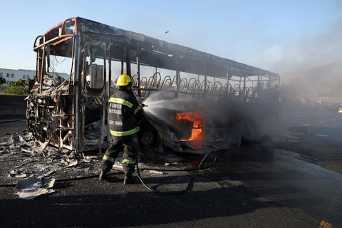Một chiếc xe buýt bị những người đình công đốt cháy. (Nguồn: Reuters)