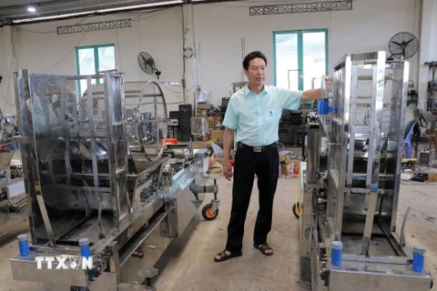 Anh Nguyễn Hồng Chương giới thiệu máy gieo hạt chân không 6 trong 1. (Ảnh: Chu Quốc Hùng/TTXVN)